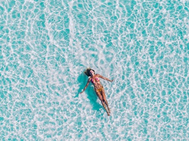 Lady floating in the clear sea