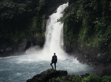 A man backpacking through a waterfall